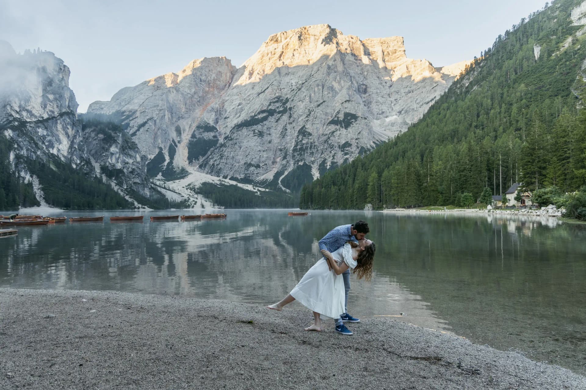 Novomanželé u horského jezera při východu slunce