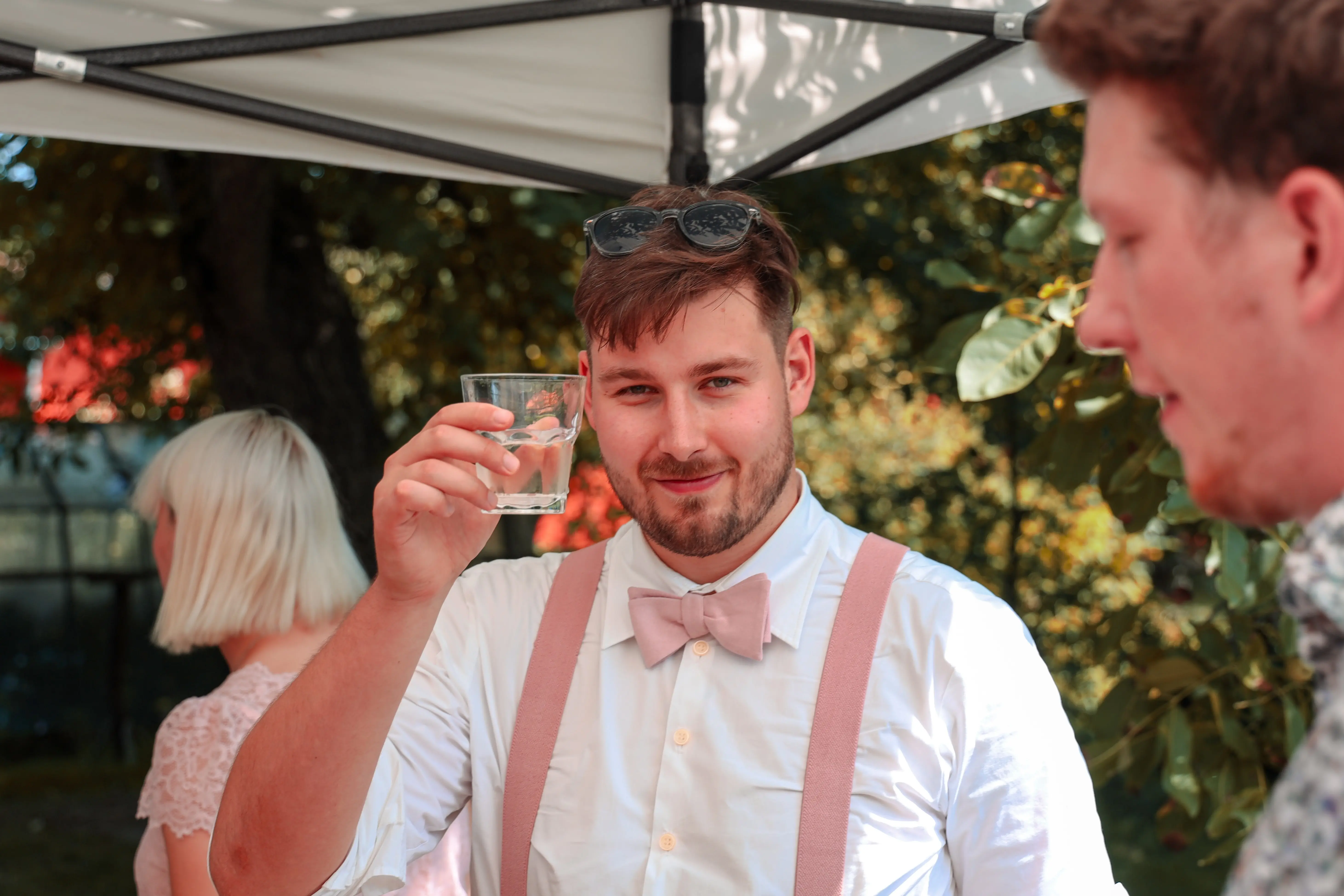 Svatebčan s dobrým drinkem na zahradní svatbě